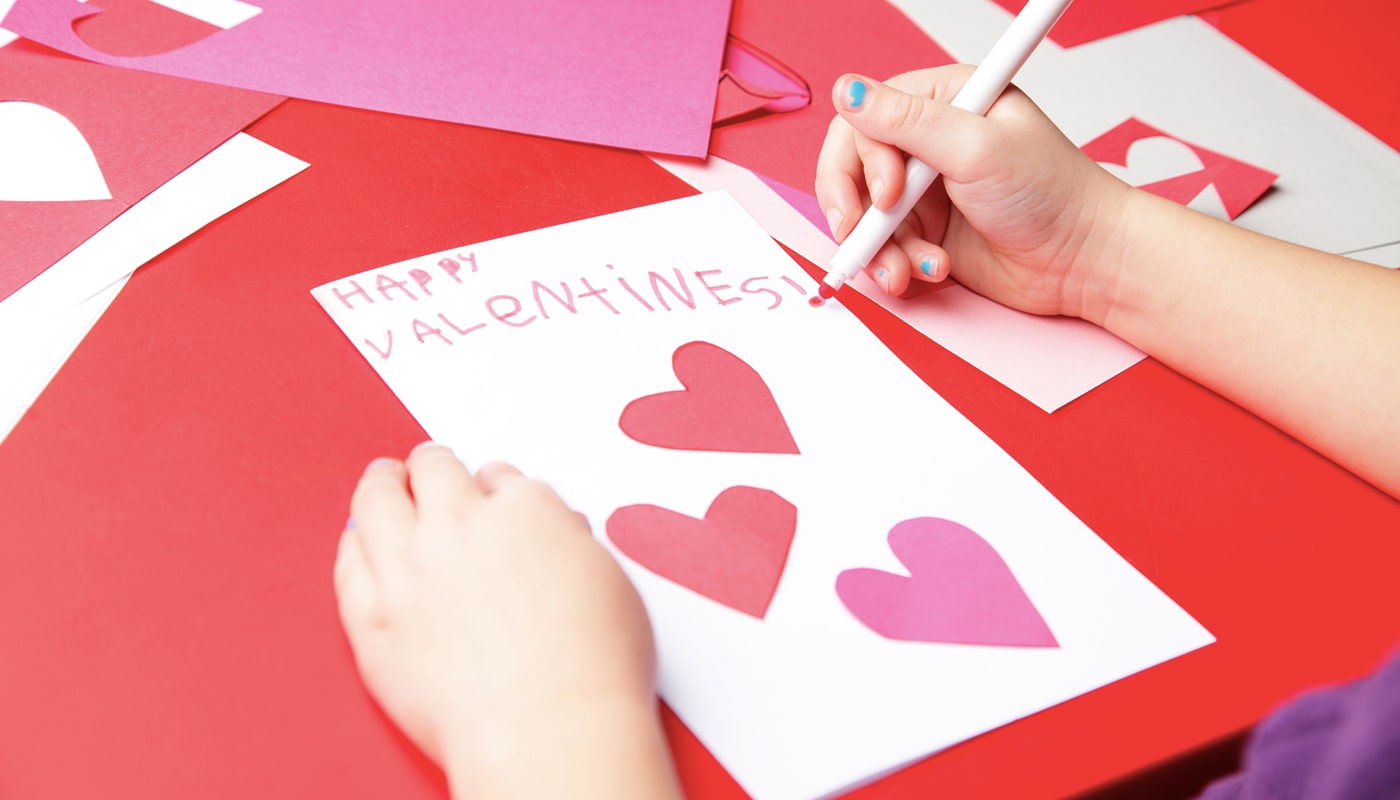 A child draws a hand made valentine card