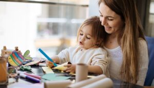 A mom and daughter doing paper crafts together and learn how to use a laminator