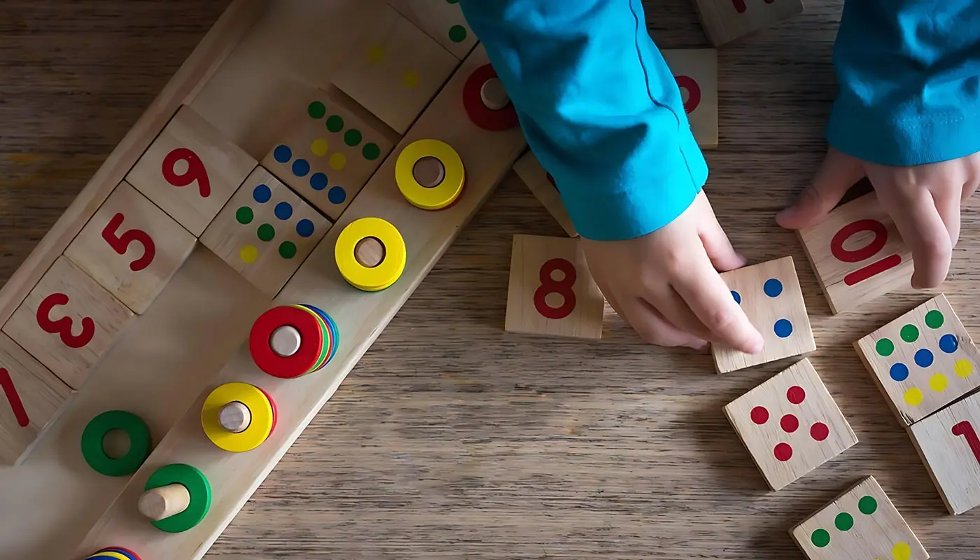 A child is learning to count with wooden number blocks and dice.