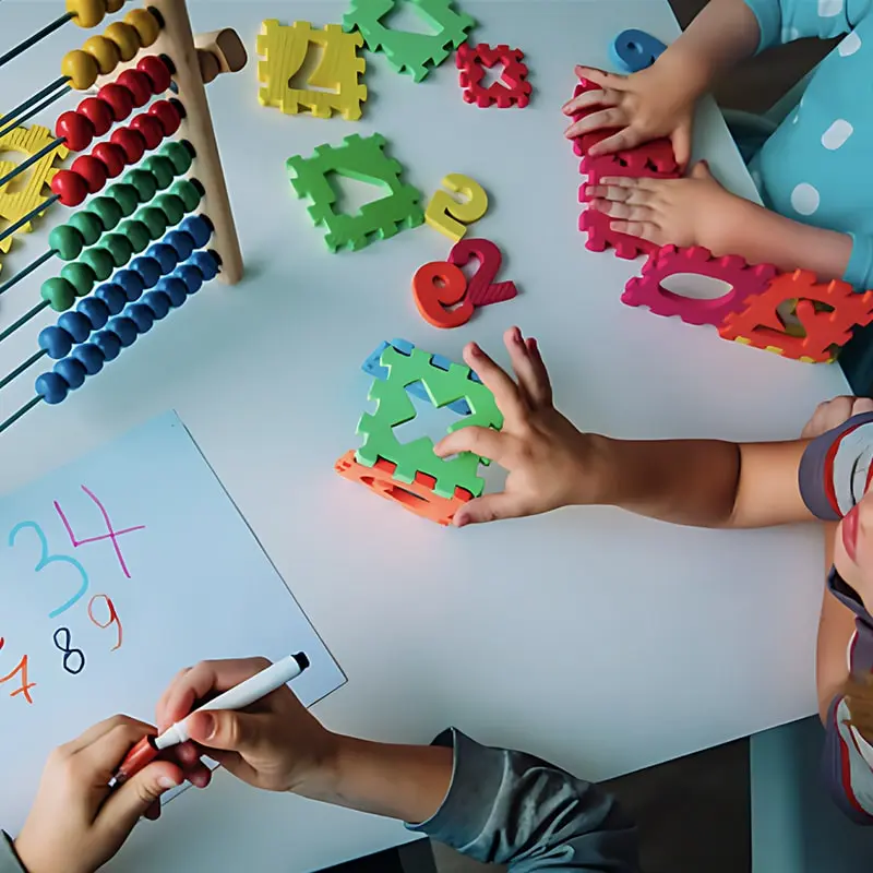 Several children are using an abacus, foam blocks, and writing numbers as they learn how to count to 10.